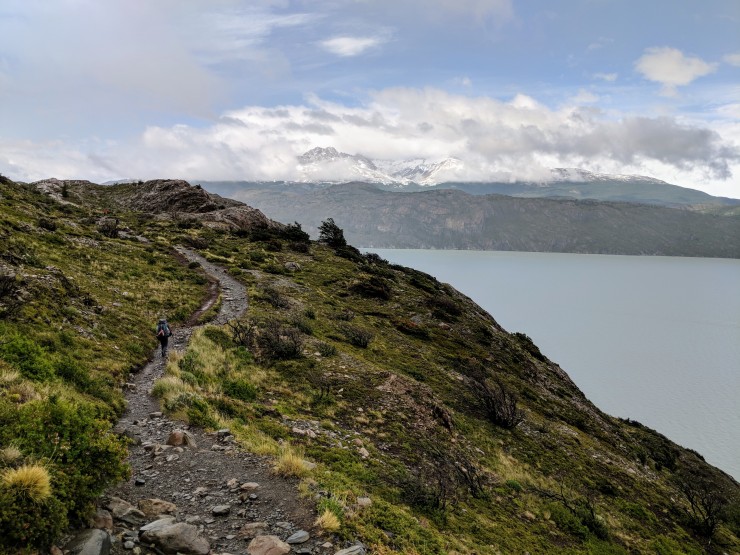 The trail skirts on the top of a drop-off that leads to the Lago Grey shore.